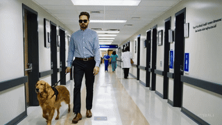 A blind person walking in hospital corridor.