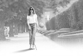 Blind woman walking independently outdoors using a white cane